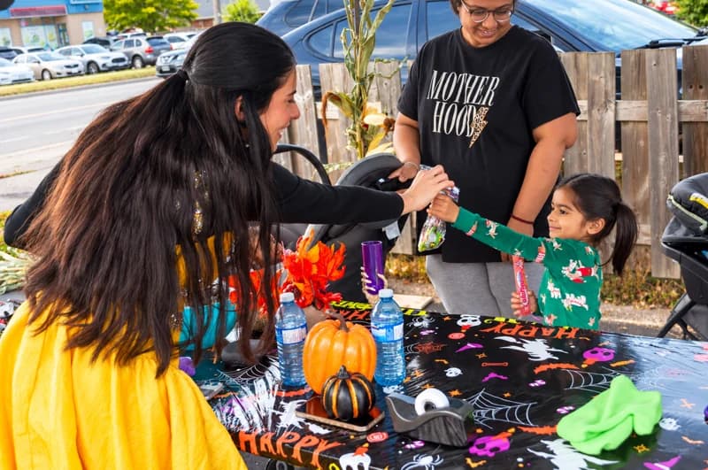 An adult and child exchange a high-five across a decorated event table.